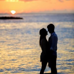 two people falling in love unexpectedly in front of a hawaiian sunset